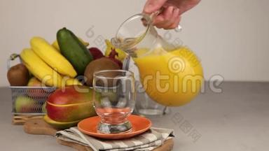 在玻璃杯中倒入脱脂剂中的果汁。 一杯果汁。 黄色清爽夏日<strong>饮品</strong>.. 鲜芒果汁，橙汁.. 果果